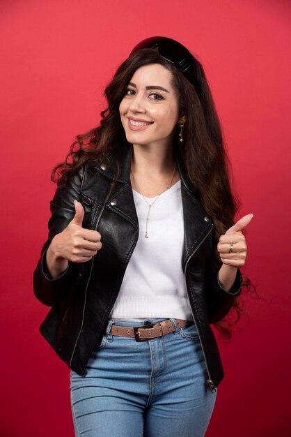 Young woman posing with black glasses on a red background. High quality photo