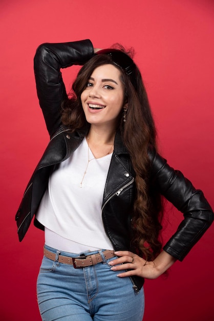 Young woman posing with black glasses on a red background. High quality photo