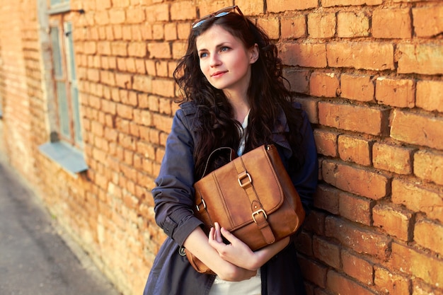 Free photo young woman posing with brick wall background