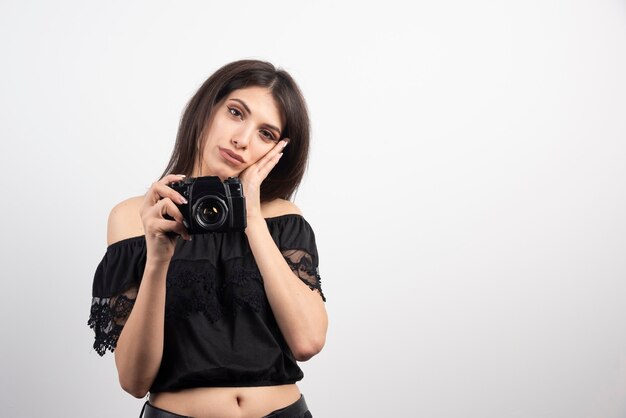 Молодая женщина позирует с камерой