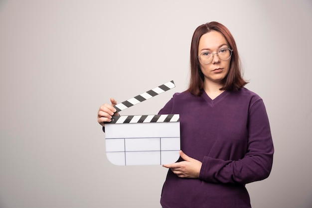 Young woman posing with a cinema tape on a white . High quality photo