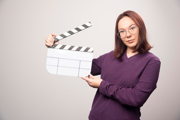 Молодая женщина позирует с лентой кино на белом. Фото высокого качества