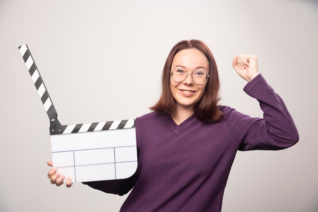 Young woman posing with a cinema tape on a white . High quality photo