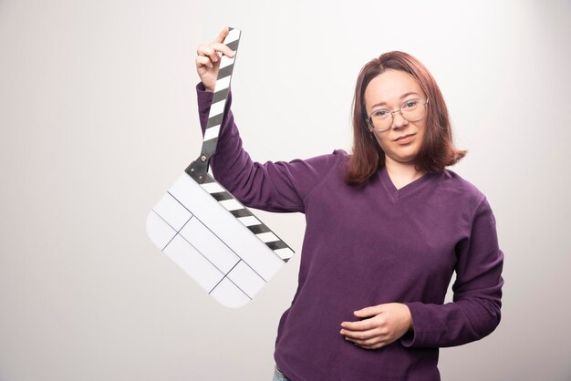 Foto gratuita giovane donna in posa con un nastro cinematografico su un bianco. foto di alta qualità