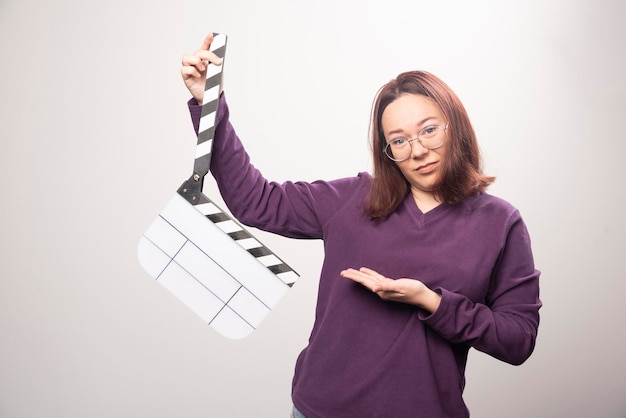 Free photo young woman posing with a cinema tape on a white . high quality photo