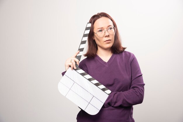 Young woman posing with a cinema tape on a white . High quality photo