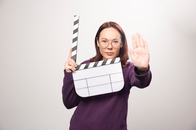 Young woman posing with a cinema tape on a white . High quality photo