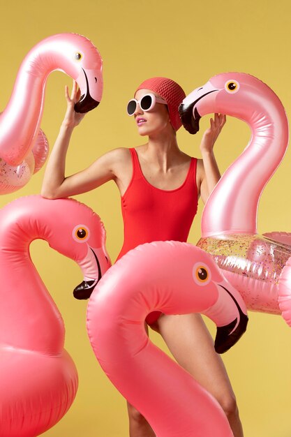 Молодая женщина позирует с плавательным кольцом фламинго