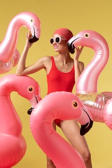 Молодая женщина позирует с плавательным кольцом фламинго