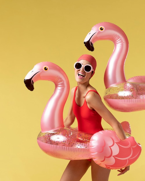 Young woman posing with flamingo swimming ring