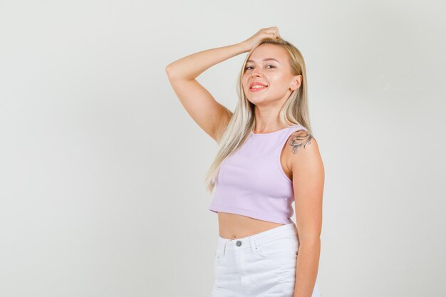 Young woman posing with hand on head in singlet