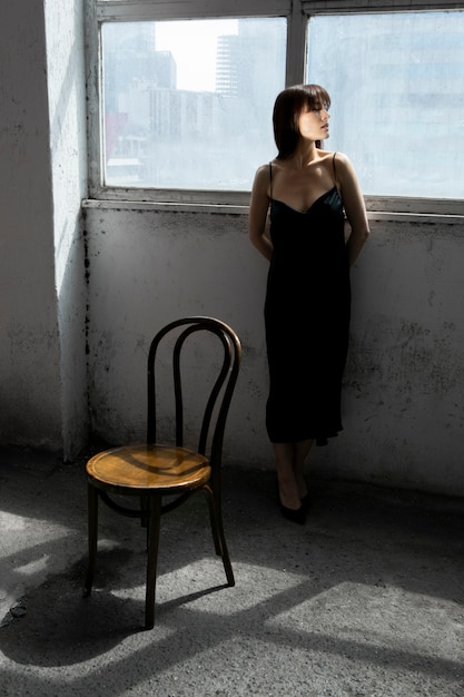 Free photo young woman posing with mirror and chair