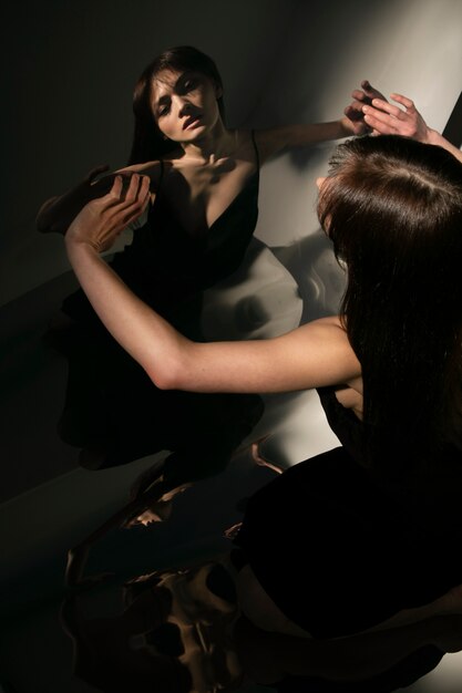 Young woman posing with mirror reflection