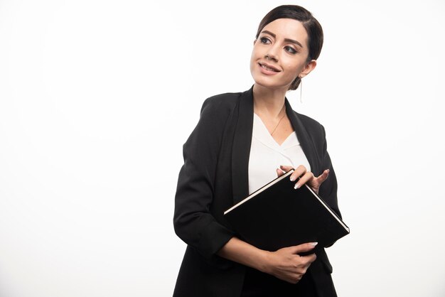 Young woman posing with notebook on white background. High quality photo