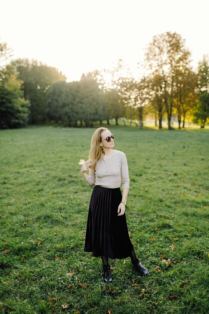 Young Woman Posing Over Yellow Leaves In The Autumn Park. Outdoor