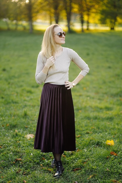 Free photo young woman posing over yellow leaves in the autumn park. outdoor