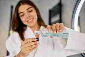 Free photo young woman pouring mouth wash