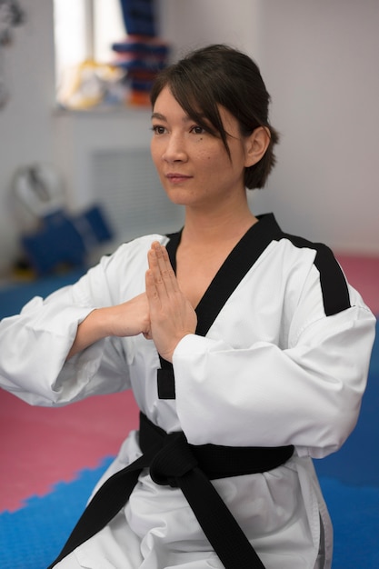 Foto gratuita giovane donna che pratica il taekwondo in una palestra