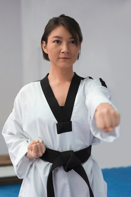 Foto gratuita giovane donna che pratica il taekwondo in una palestra