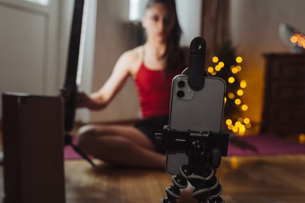 Young woman practicing yoga is engaged with the teacher online