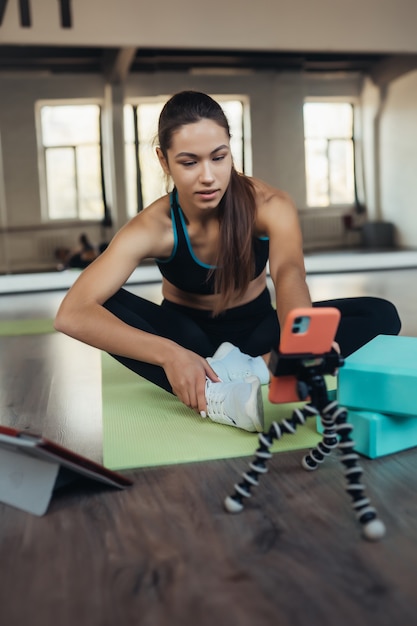 Foto gratuita la giovane donna che pratica lo yoga è impegnata con l'insegnante online.