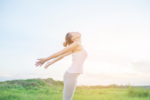 Молодая женщина практикует позы йоги на открытом воздухе
