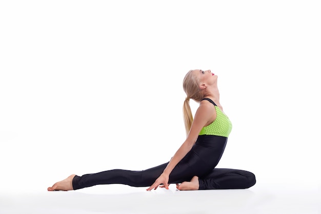молодая женщина практикует йогу, сидя на полу, вытянув спину