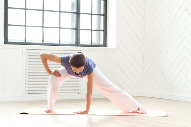 Young woman practicing yoga on a yoga mat