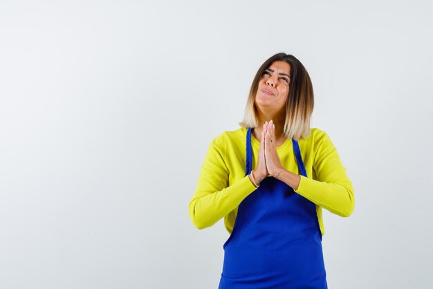 Young woman praying on white background