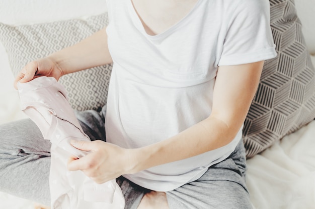 Young woman preparing clothes for baby