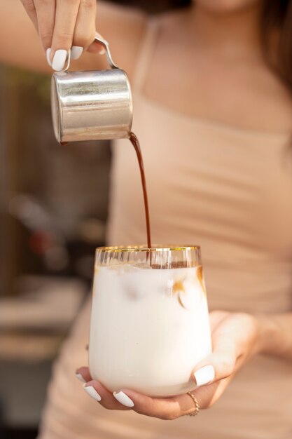 Young woman preparing iced coffee