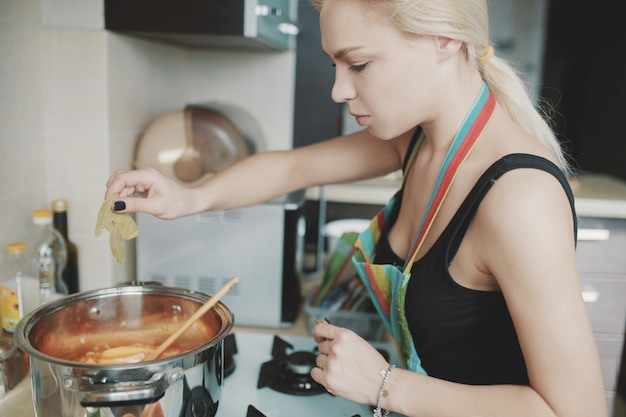 Giovane donna che prepara la zuppa di zucca