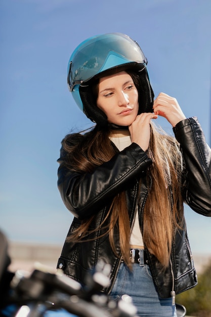 Giovane donna che si prepara a guidare in una moto in città
