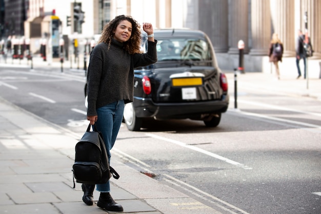 도시에서 택시를 멈출 준비를 하는 젊은 여성