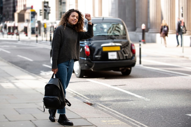 Young woman preparing to stop a taxi in the city