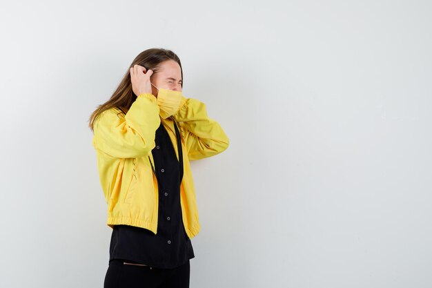 Young woman pressing hands on ears and looking annoyed