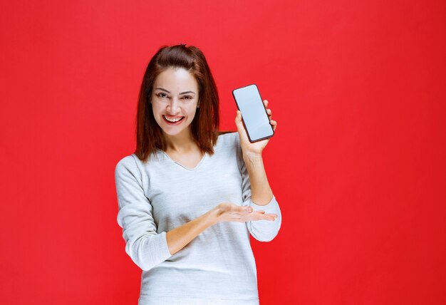 Young woman promoting the new model of a smartphone brand