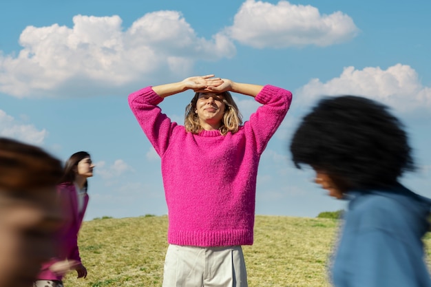 Foto gratuita giovane donna che protegge i suoi occhi dal sole in un campo all'aperto