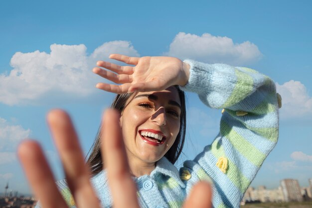 屋外のフィールドで太陽から目を保護する若い女性