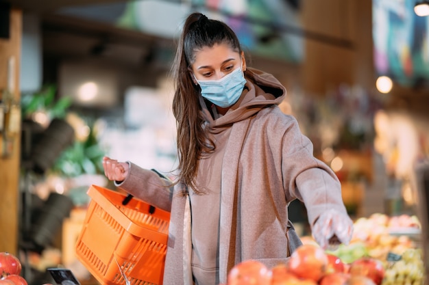 Young woman in protective mask makes purchases