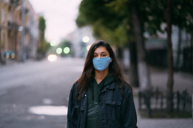 빈 거리에서 보호 의료 마스크에 젊은 여자