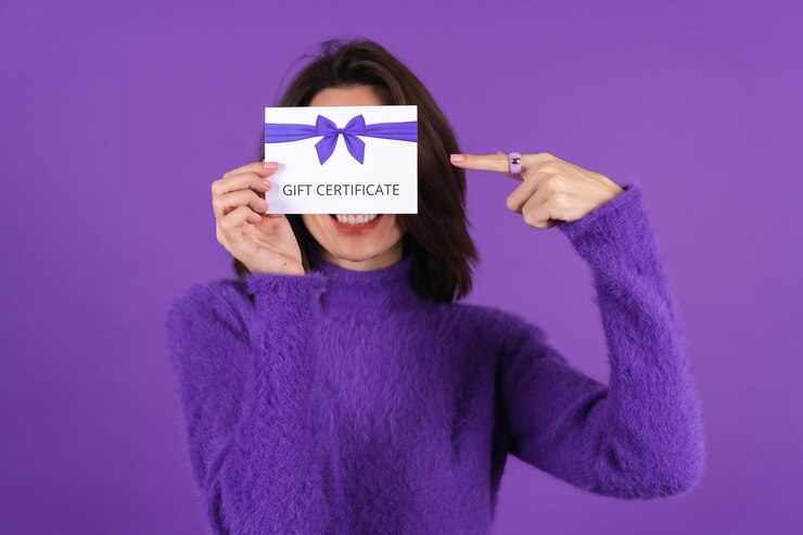 Free Photo young woman in purple soft cozy sweater with gift voucher