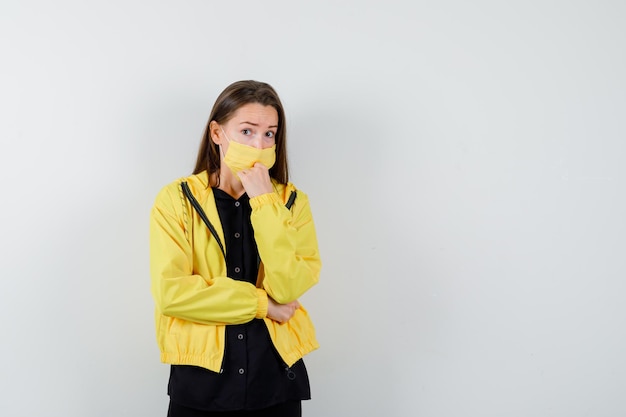 Young woman putting fist on chin and looking serious