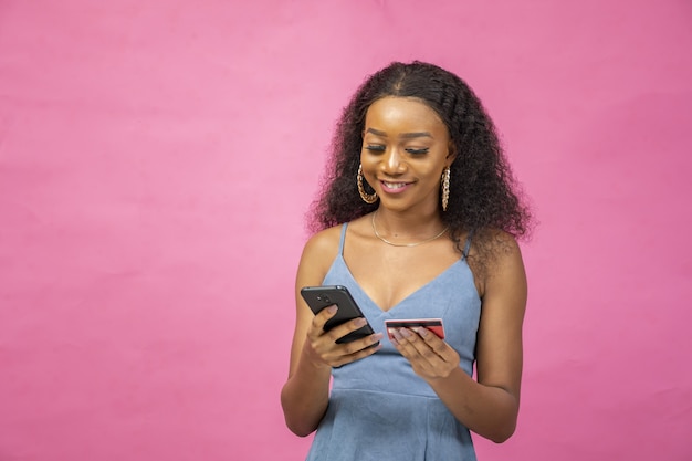 Young woman putting her credit card information in her cellphone