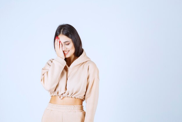 Young woman putting her hand to her face and listening with joy