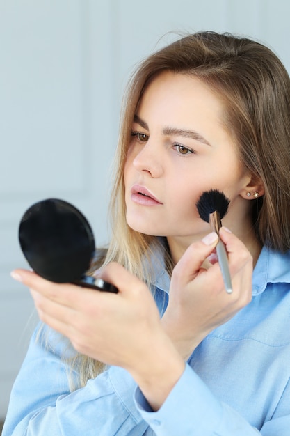 Young woman putting on makeup.
