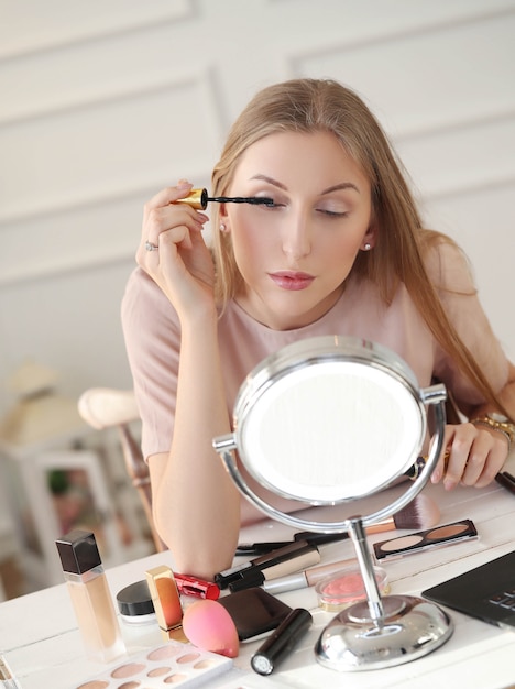 Young woman putting on makeup