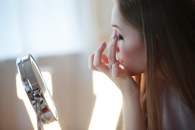 Young woman putting on makeup