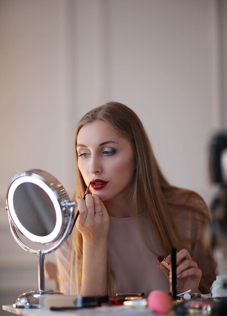 Young woman putting on makeup