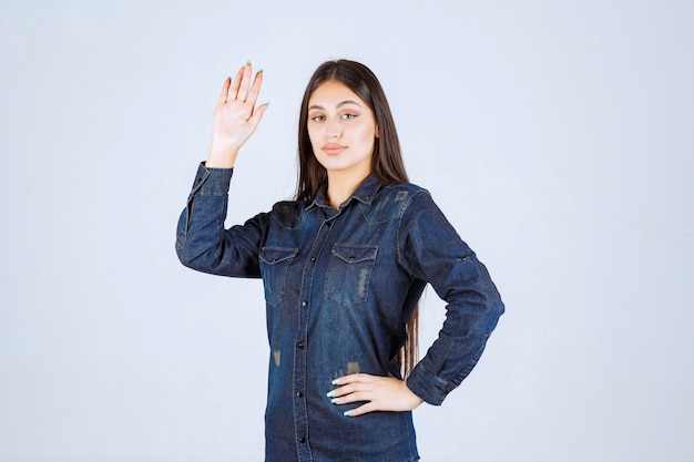 Young woman raising her hand for getting attention
